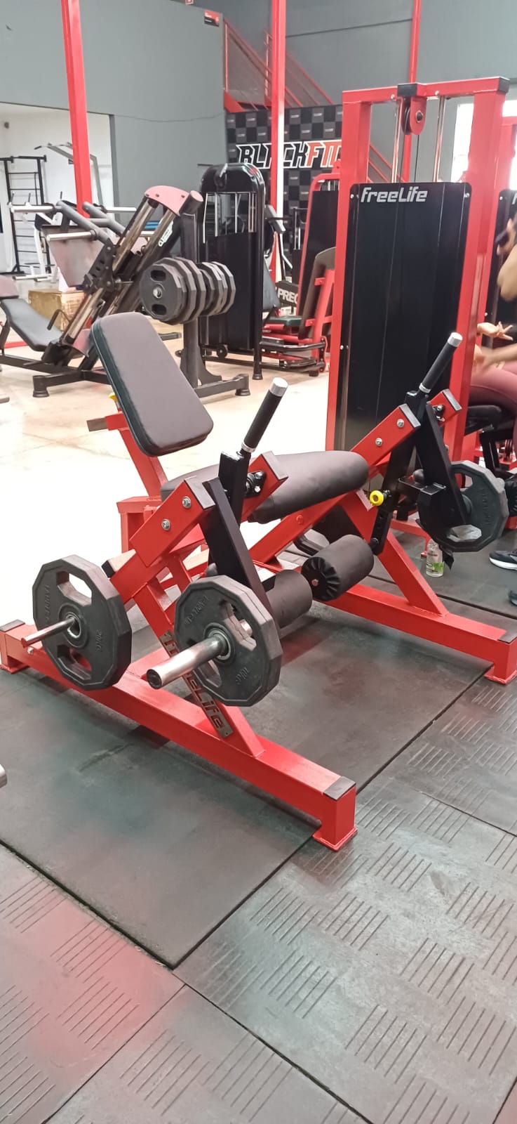 Máquina de musculação Freelife vermelha em uma academia